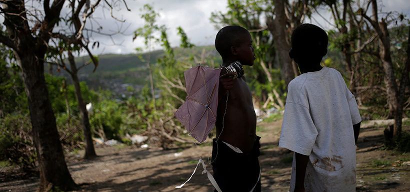 Children chat in the yard of a temporary shelter after Hurricane Matthew hit Jeremie, Haiti