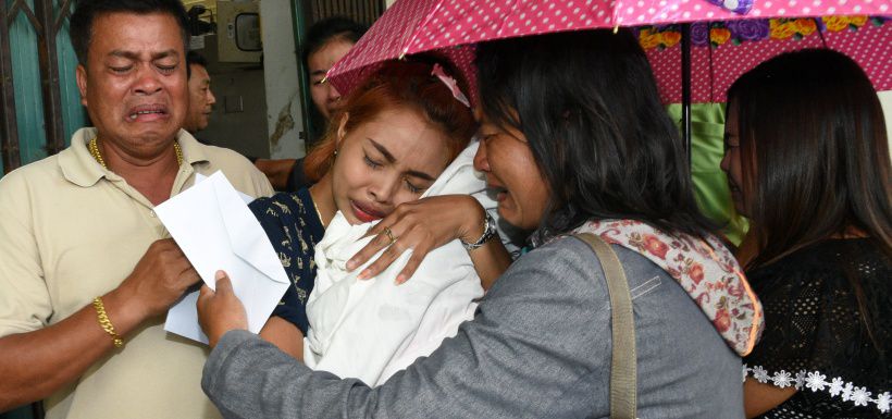 Jiranuch Trirat holds up the body of her 11-month-old daughter who was killed by her father, at a hospital in Phuket