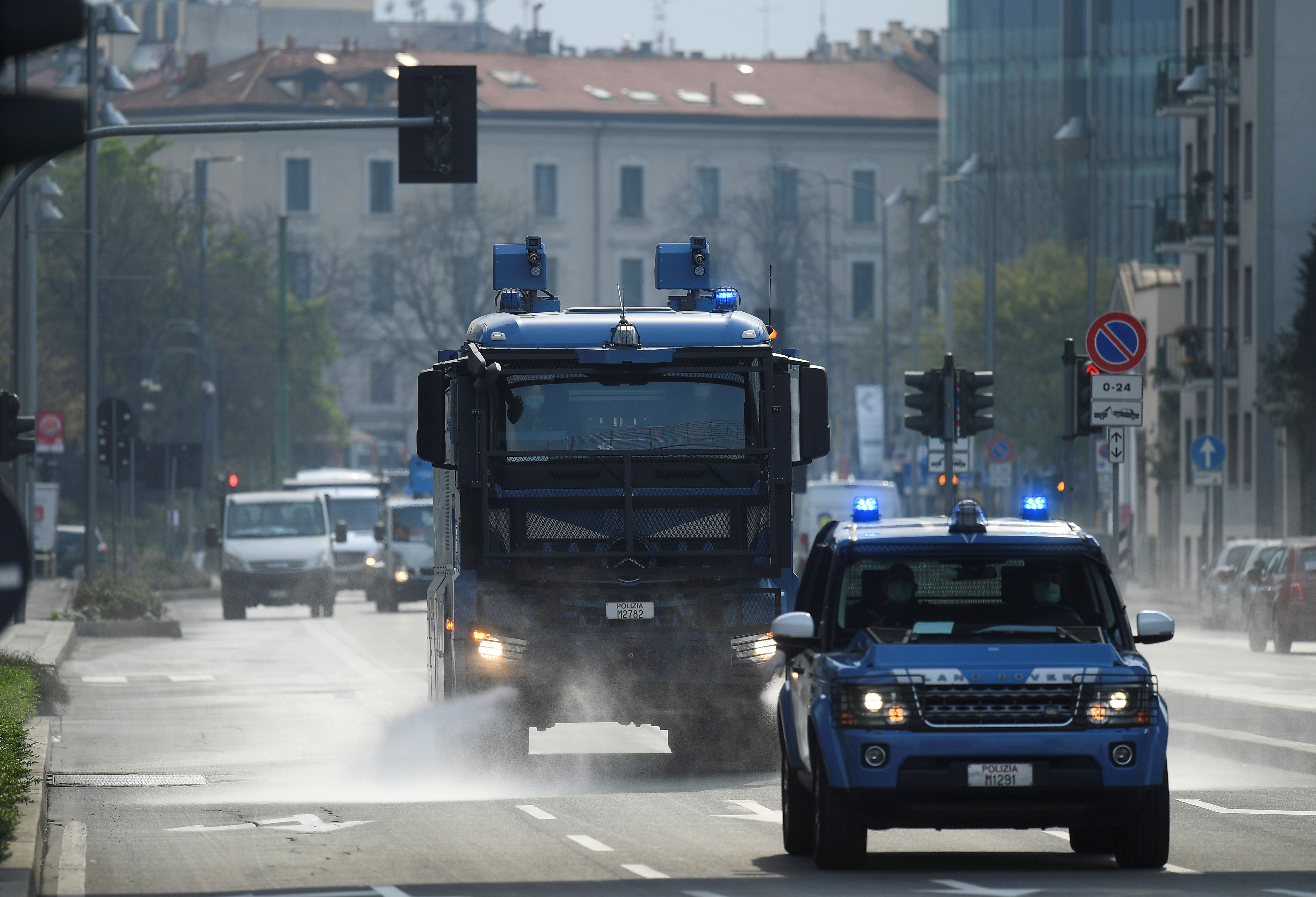 Un vehículo de la policía italiana sanitiza las calles de Milán.