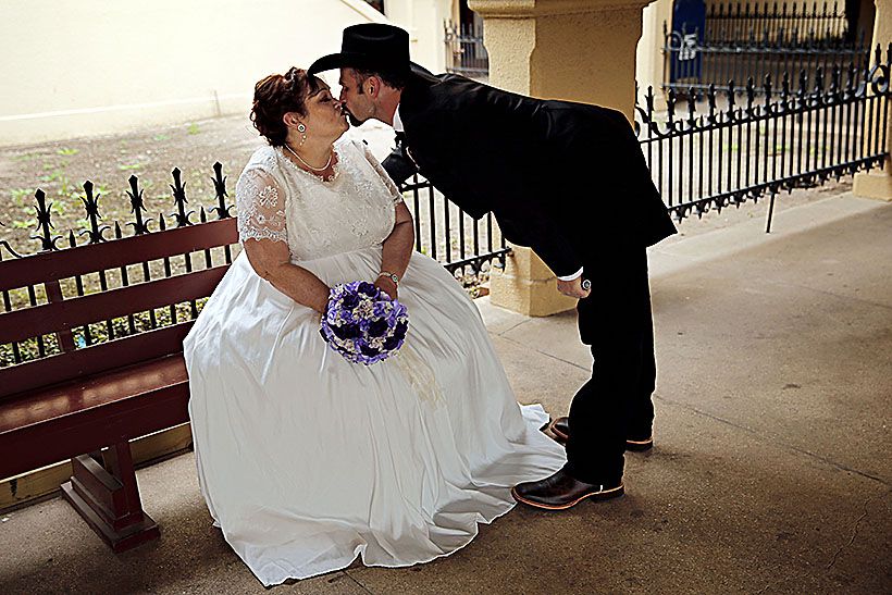 Off the Wall: Cowboy groom kisses his bride before the mass wedding in the  Stockyards