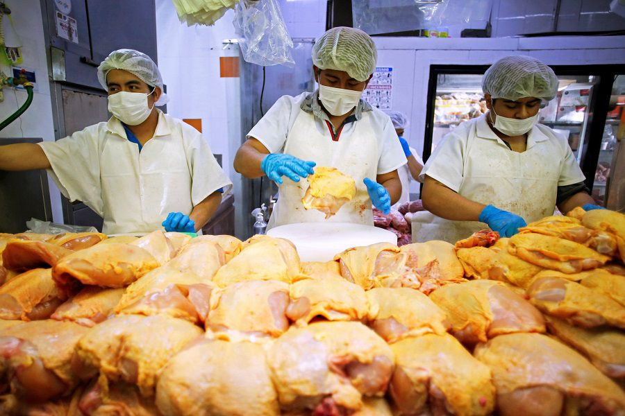 Workers prepare chicken at a food stall in the Central de Abastos wholesale market in Mexico City