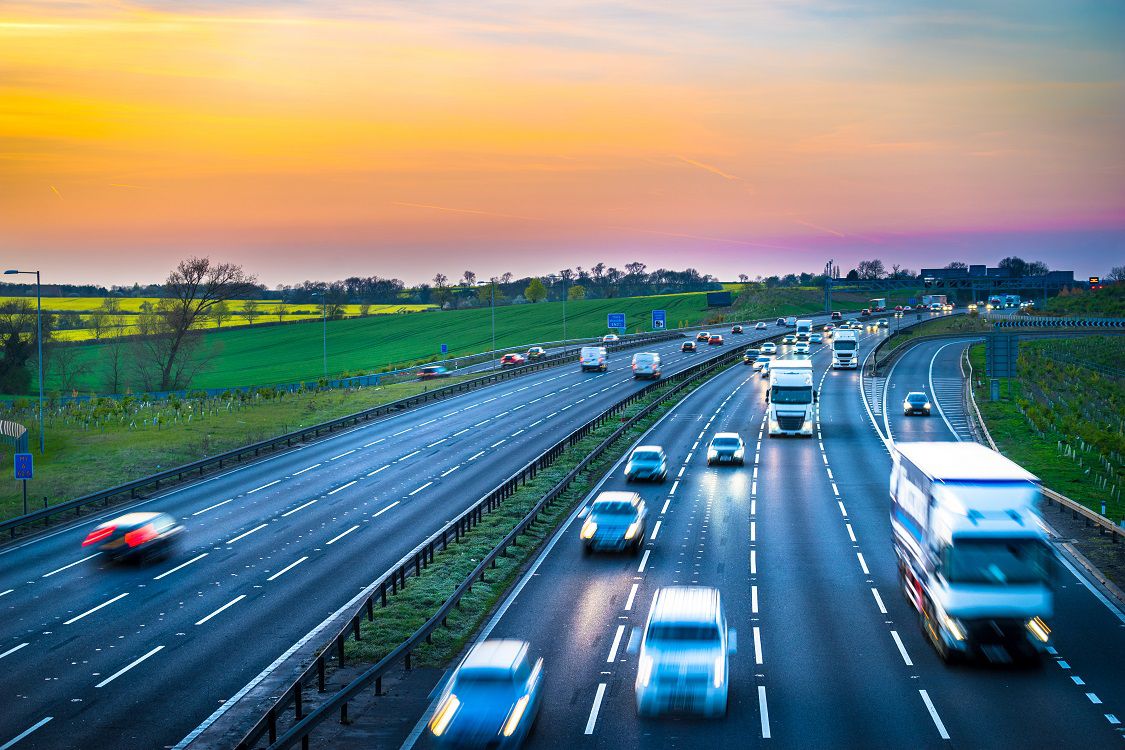 Colourful sunset at M1 motorway near Flitwick junction with blurry cars in United Kingdom.