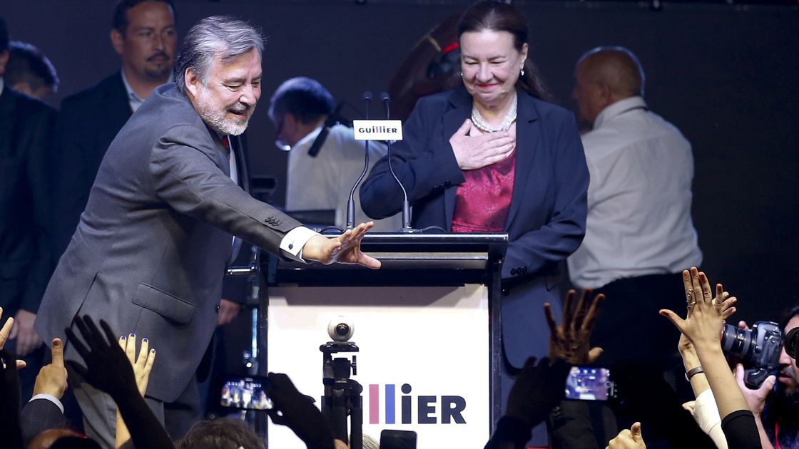 Chilean presidential candidate Alejandro Guillier next to his wife Cristina Farga,  waves to supporters after the results of the first round vote during the presidential elections in Santiago.