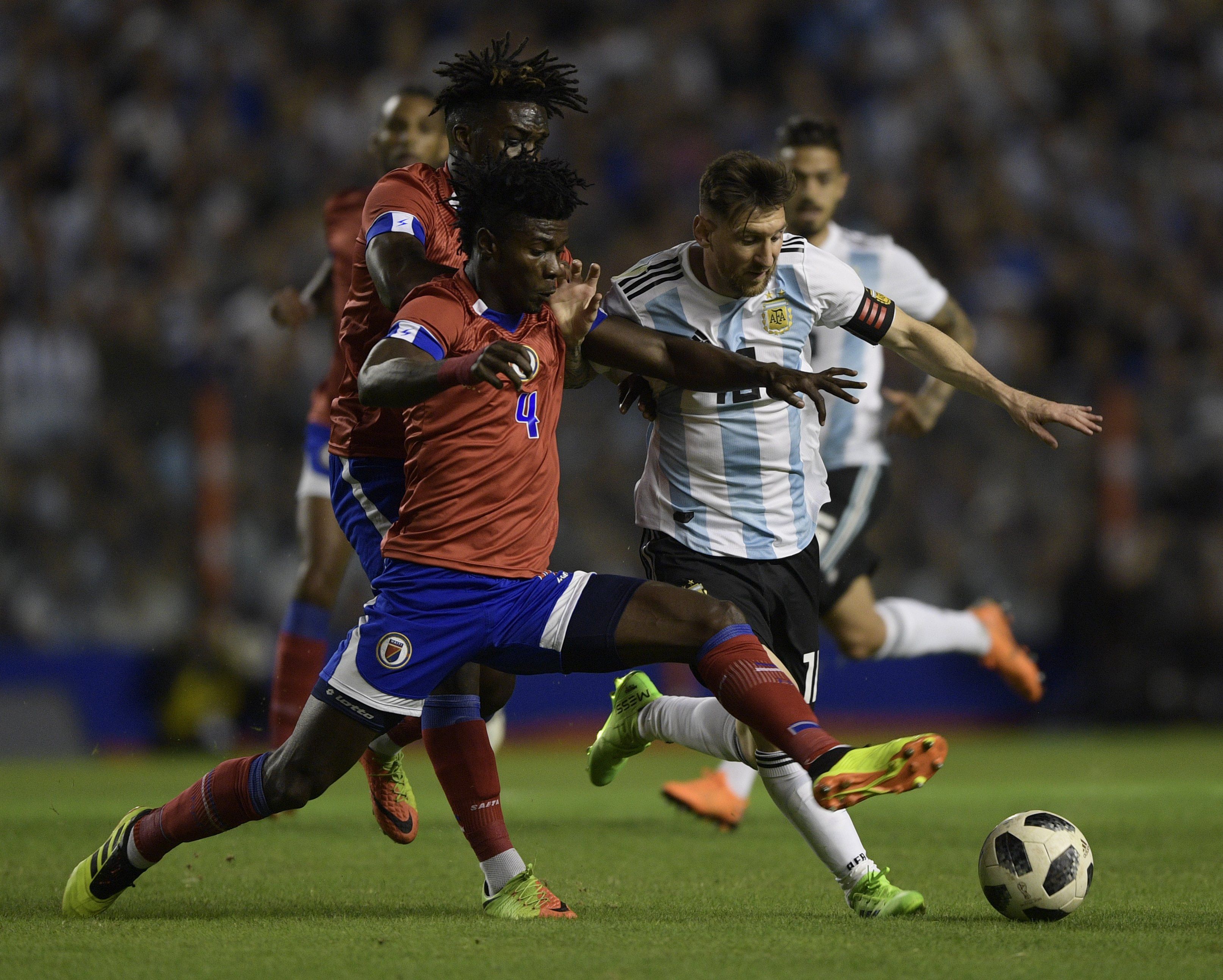 Argentina's Lionel Messi (R) vies for the ball with Haiti's Ricardo A