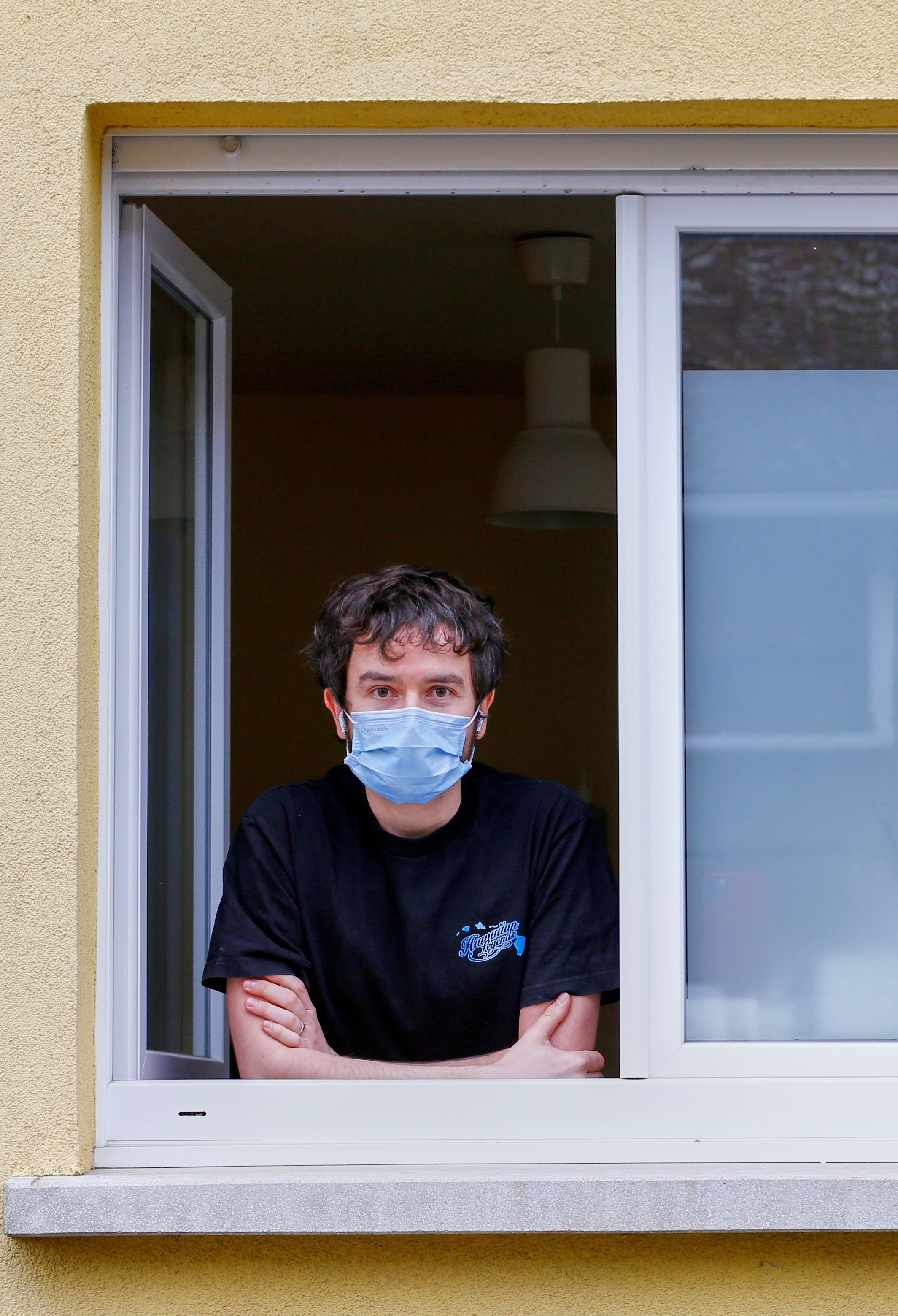 FILE PHOTO: Jonathan Peterschmitt poses at his window during his home quarantine in Bernwiller