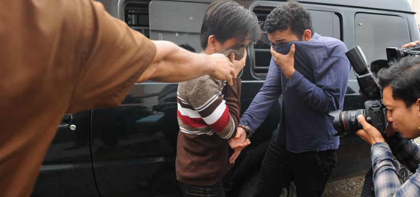 Two Indonesian men arrive for their trials at a shariah court in Band