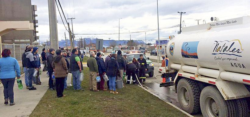 Vecinos haciendo fila para recolectar agua.