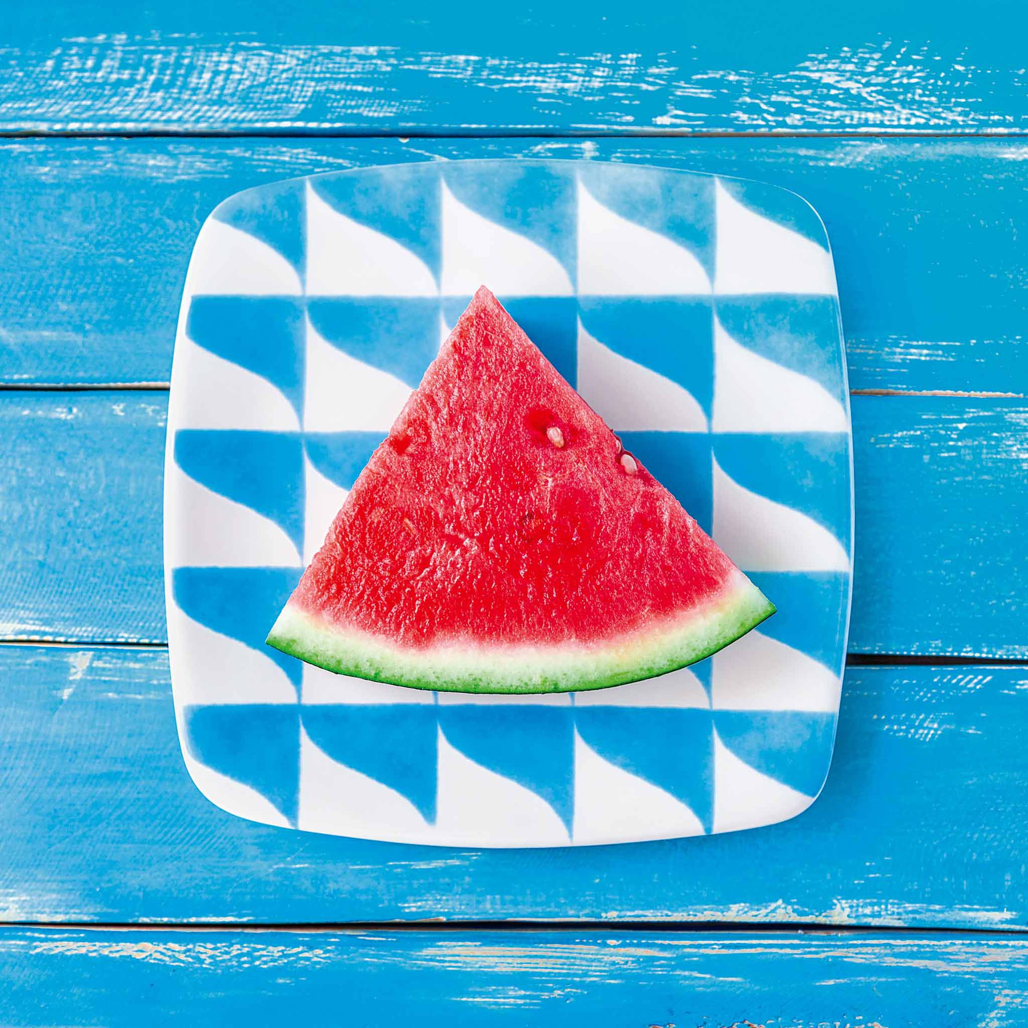 Elevated view of a fruit on a plate. Blue wooden background.