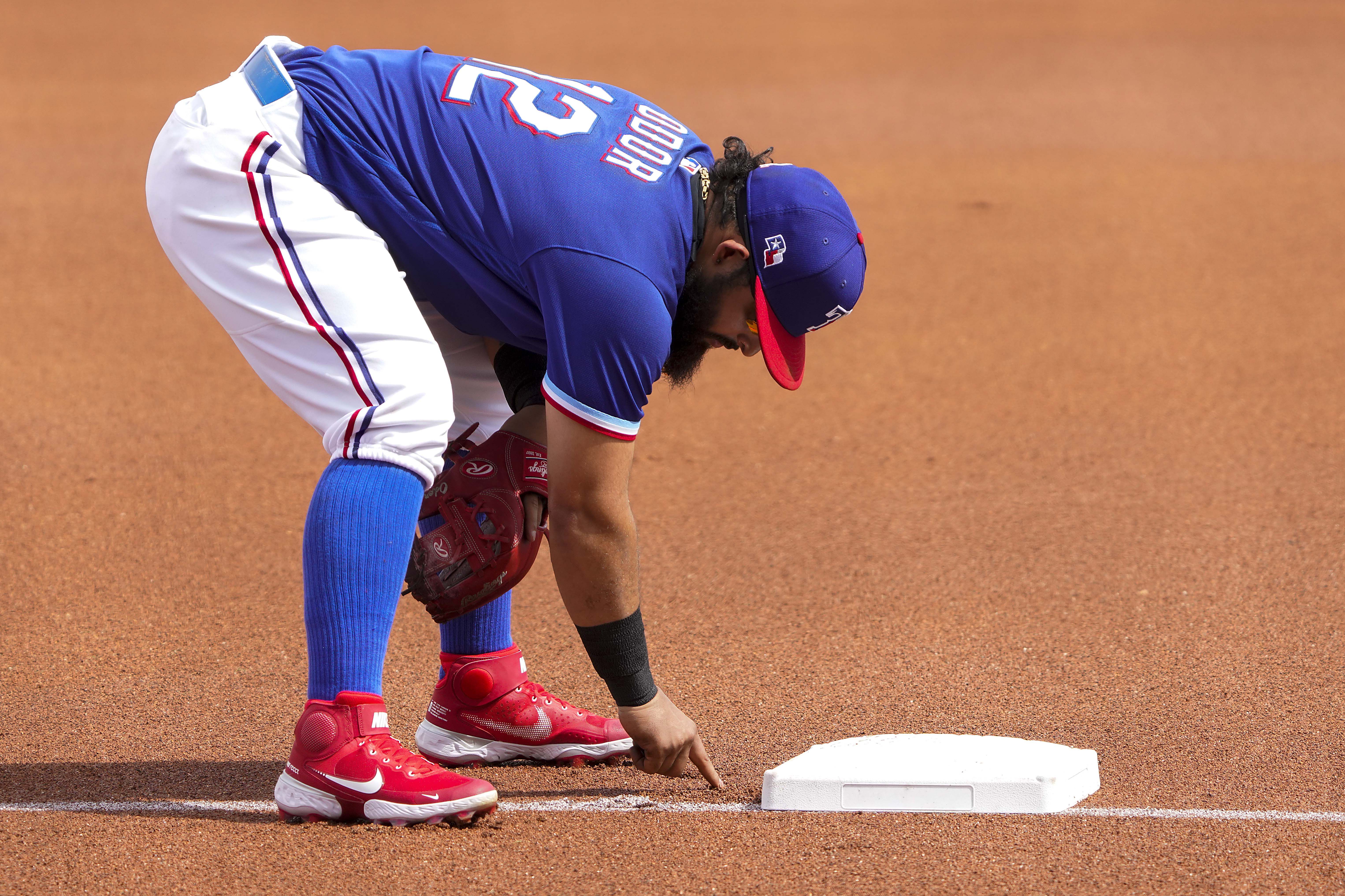 Texas Rangers third baseman Brock Holt (16) blows a bubble during a  baseball game against the