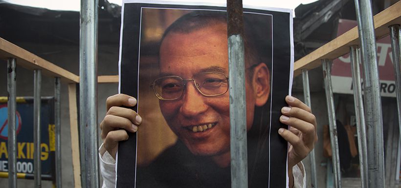 An exile Tibetan holds a portrait of the Chinese Nobel laureate Liu X