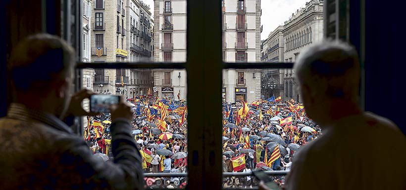 Clientes de un café observan la marcha por la unidad de España el 30 de septiembre en Barcelona.