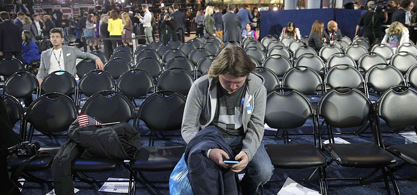 Supporter uses his smartphone as others leave Clinton rally in New York