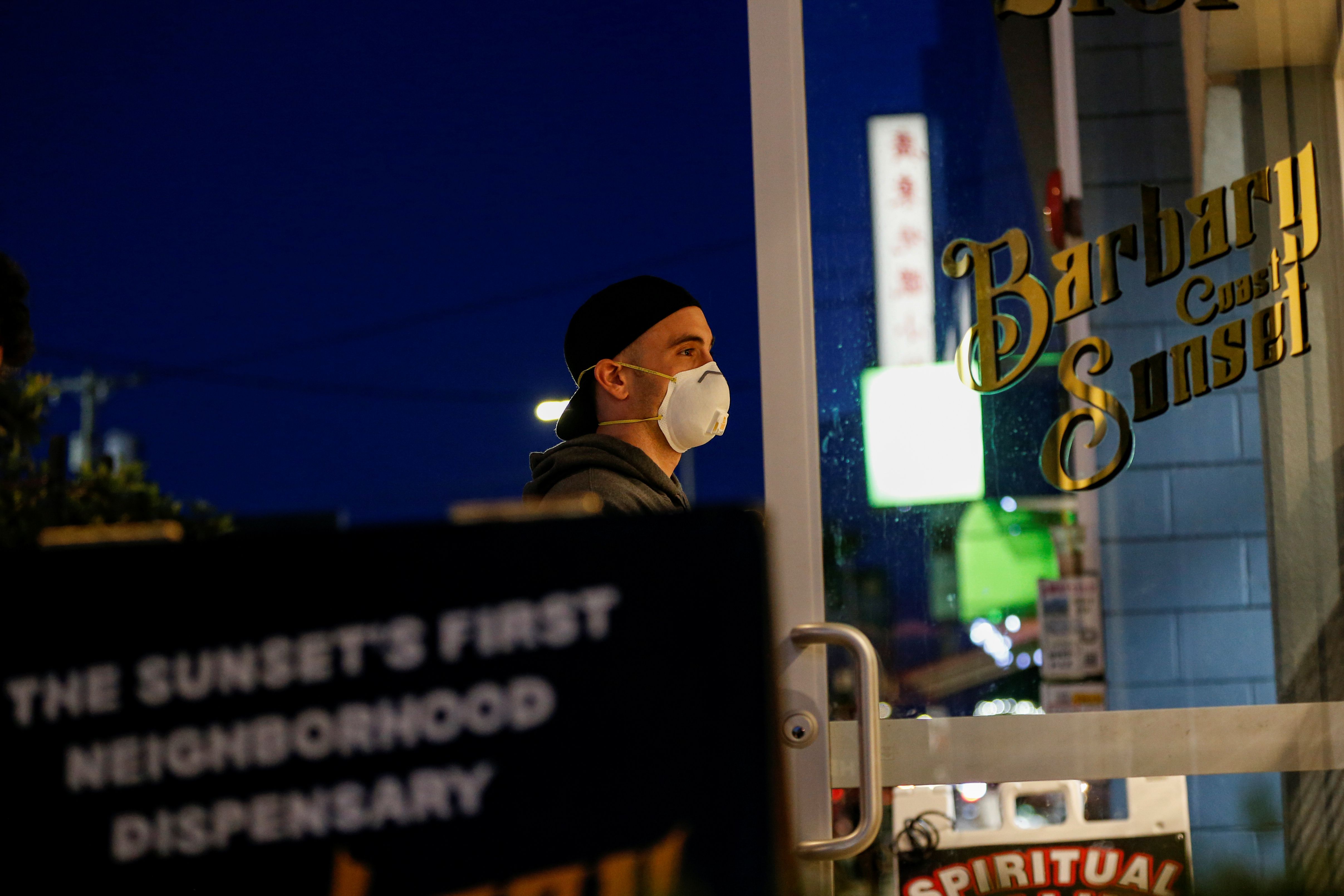 People stand in line outside the Barbary Coast Sunset Cannabis Dispensary prior to the citywide shelter in place order amid the novel coronavirus (COVID-19) outbreak, in San Francisco