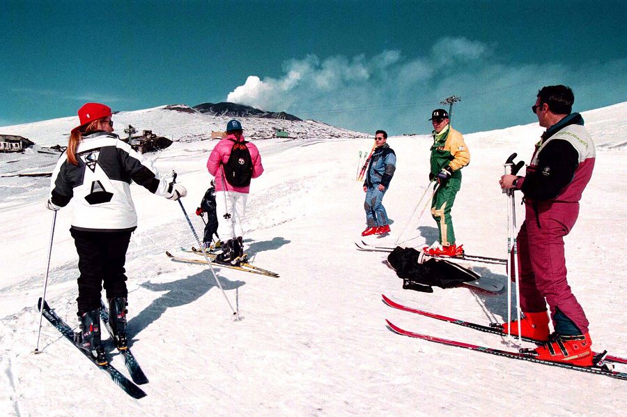 Tourists on skis look at smoke coming out of the top of Mount Etna in Sicily. Scientists from the In..