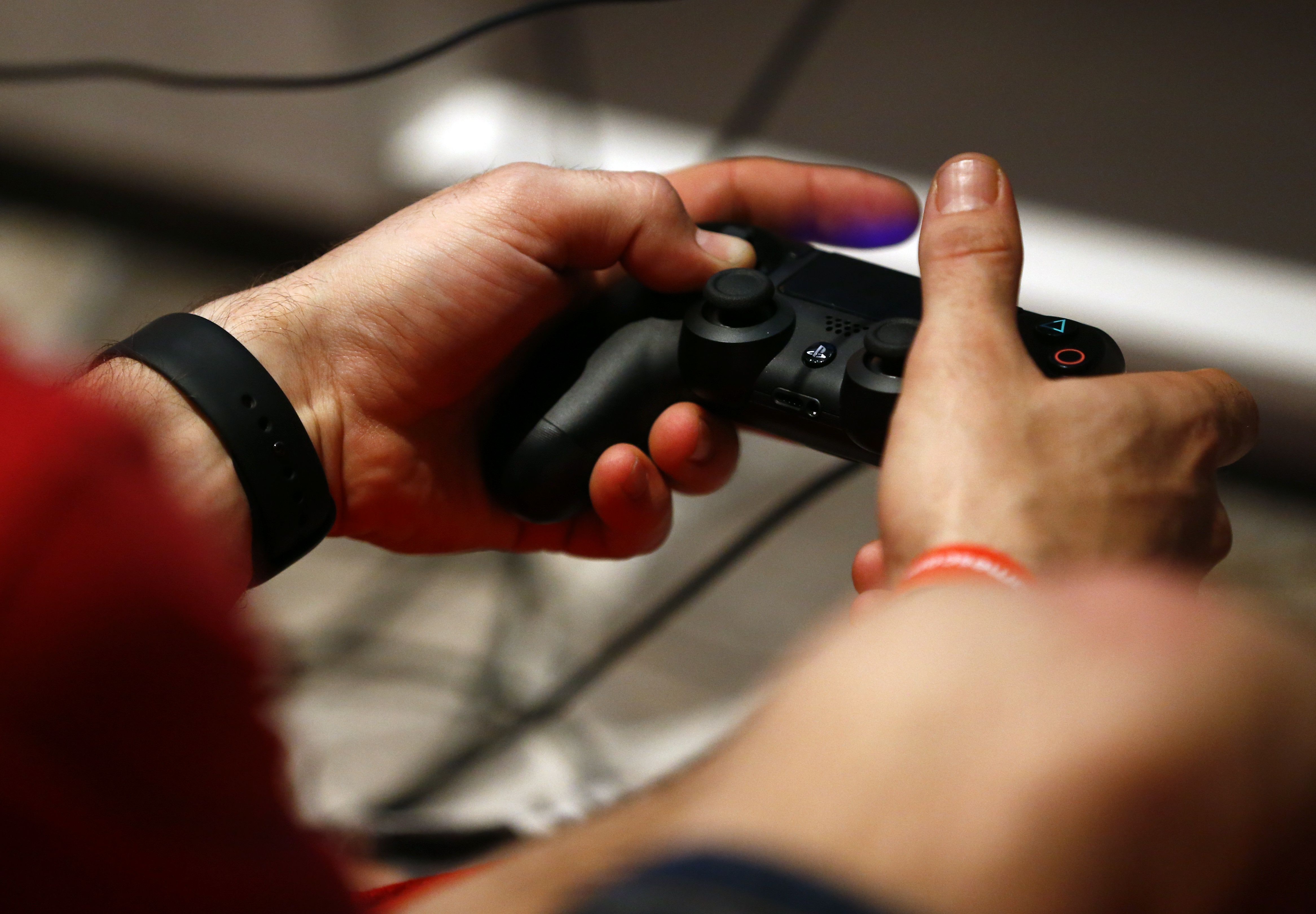 A man uses a Sony PlayStation controller during the Gamescom 2015 fair in Cologne