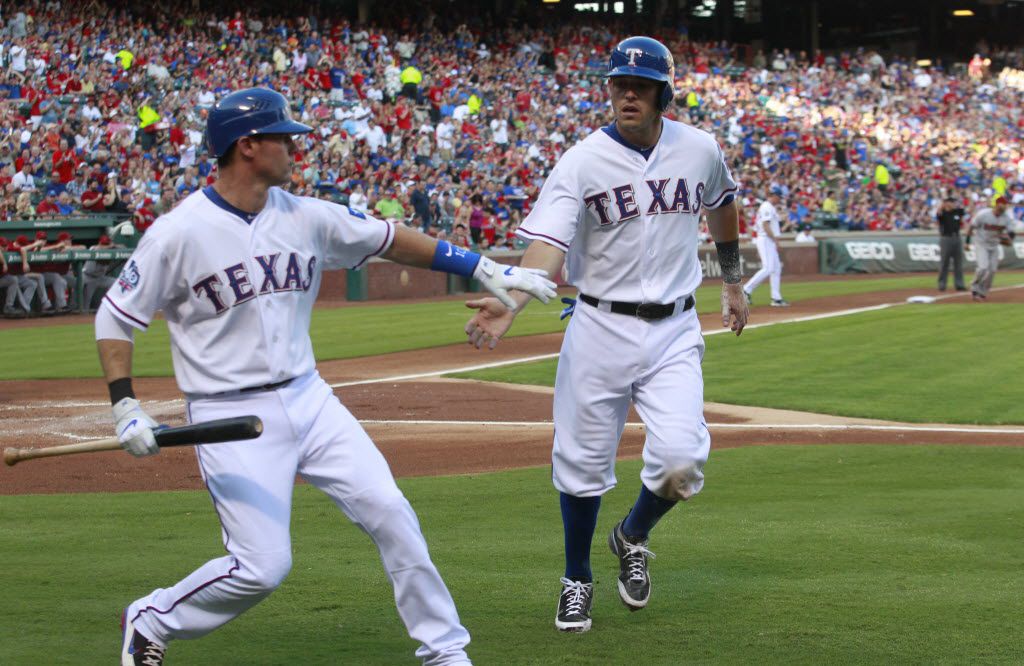 Members of the Texas Rangers staff raise the 2011 American League West  Division Champions flag at Rangers Ballpark in Arlington, Texas prior to  the Seattle Mariners game on September 24, 2011. The