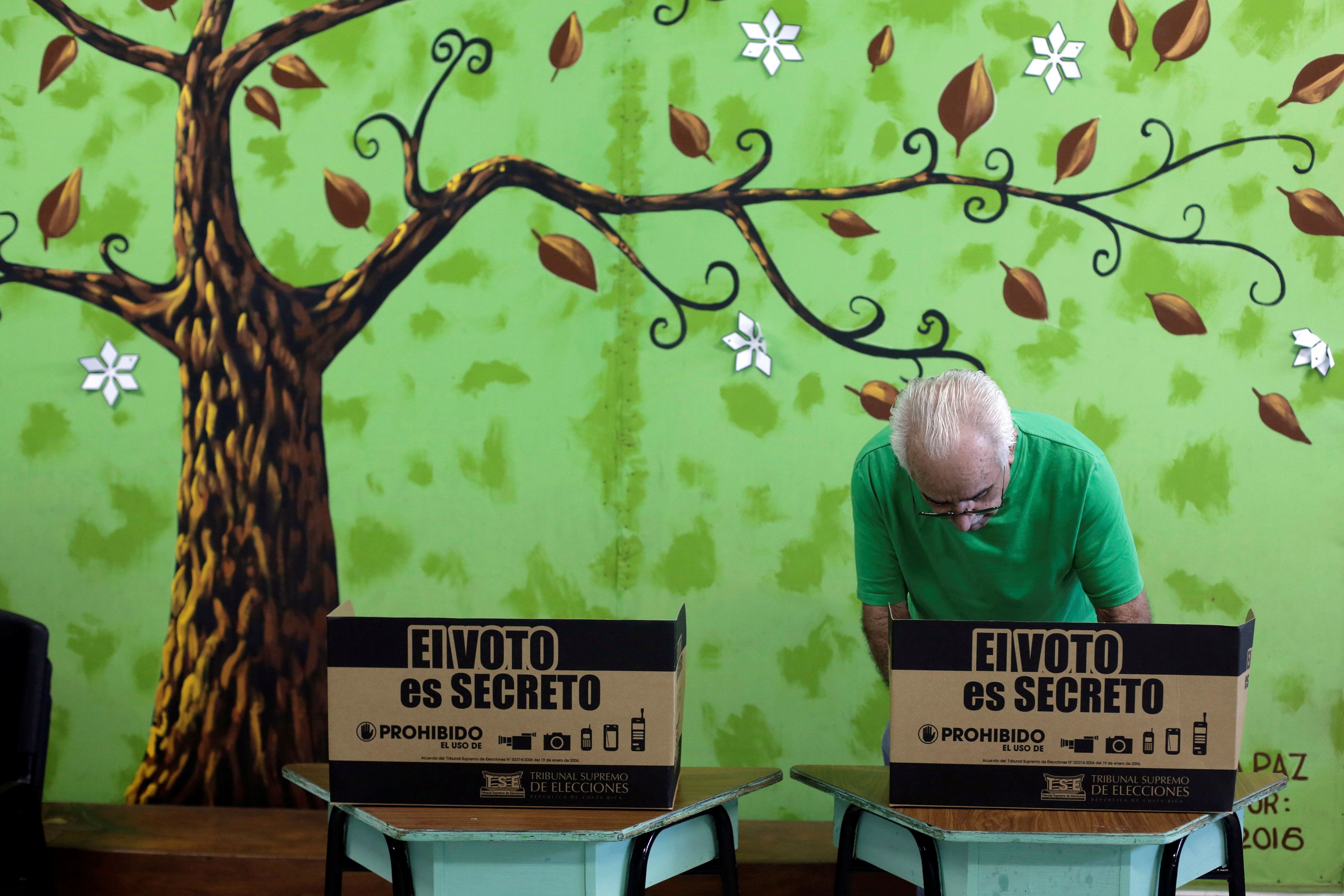 A voter prepares to cast a ballot during the presidential election at a polling station in San Jose