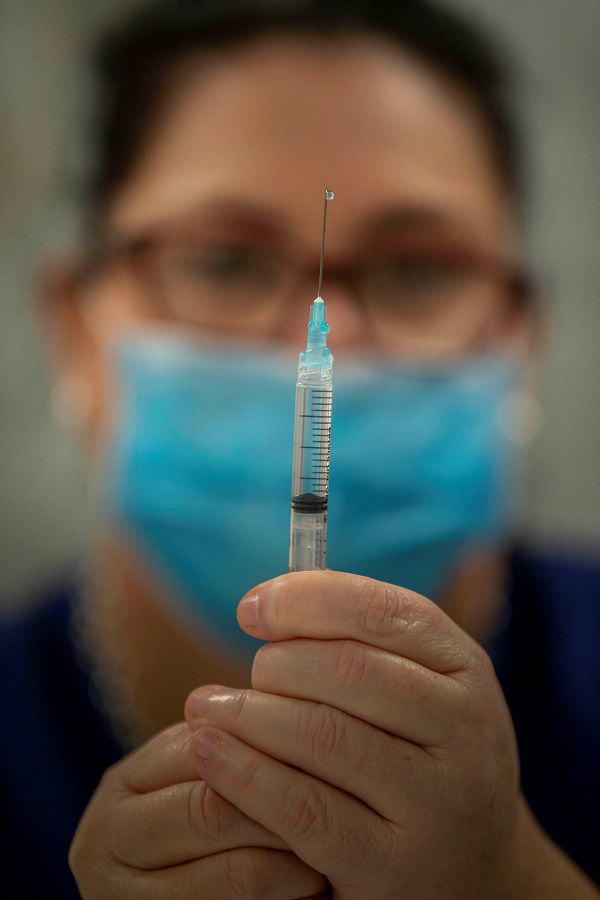 A health professional prepares a needle during a coronavirus disease vaccine development announcement in Brisbane